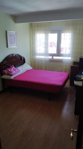 duże różowe łóżko w pokoju z oknem w obiekcie habitacion w mieście Gijón