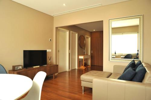 a living room with a white couch and a television at Music Apartment I in Porto
