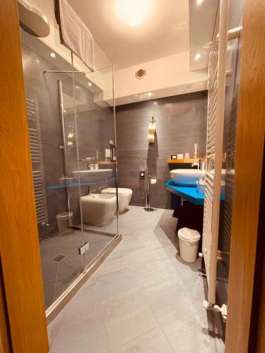 a bathroom with a shower and a sink and a toilet at Elliot Osteria e dormire in collina in Manzano