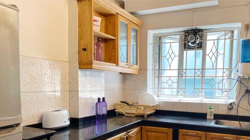 a kitchen with a sink and a window at The Aster Homestay - Bedrooms & Apartments in Kolkata