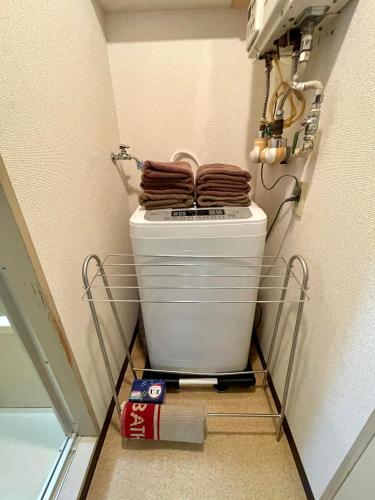 a toilet in a bathroom with towels on top of it at 新規OPEN！サービスアパ―トメントSAPPORO中島公園302 in Sapporo