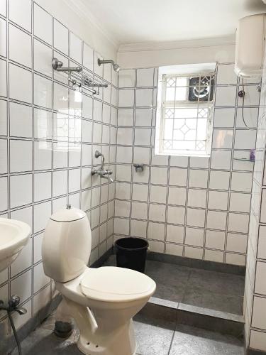 a bathroom with a toilet and a sink at The Aster Homestay - Bedrooms & Apartments in Kolkata