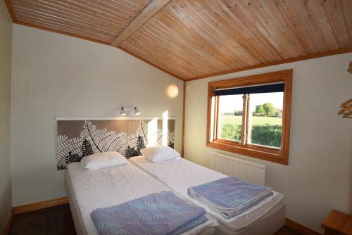 1 dormitorio con 1 cama grande y ventana en Rural holiday home on Gotland en Stånga