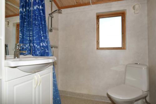 baño con aseo y lavabo y ventana en Rural holiday home on Gotland en Stånga