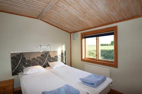 - une chambre avec un grand lit et une fenêtre dans l'établissement Rural cottage on Gotland, à Stånga