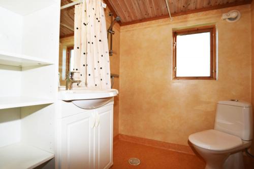 La salle de bains est pourvue de toilettes, d'un lavabo et d'une fenêtre. dans l'établissement Rural cottage on Gotland, à Stånga