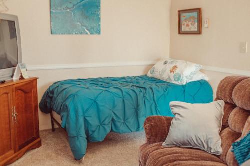 a bedroom with a bed with a blue blanket at Pioneer Inn Downtown in Homer