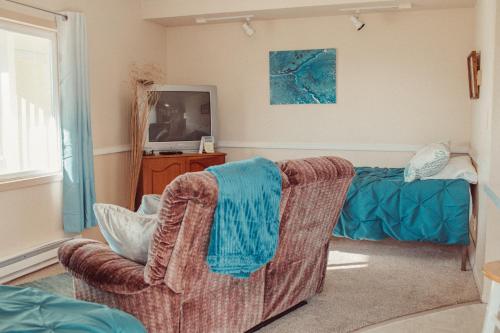 a living room with a couch and a television at Pioneer Inn Downtown in Homer
