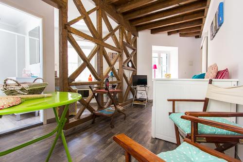 a living room with a green table and chairs at Madragoa - PLUS in Lisbon