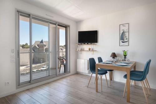un salon avec une table et des chaises et un balcon dans l'établissement A 30 mètres de la plage bel appartement pour 6, à Pornichet