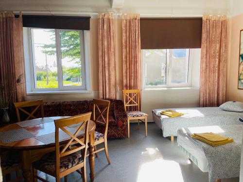 a room with a bed, table, chairs and a window at Endla Hostel in Haapsalu