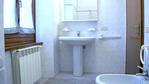 a white bathroom with a sink and a toilet at Casa Mafalda in Torre Boldone