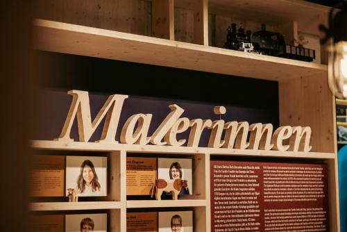 a sign for a museum with pictures on it at Bretterhotel in Brienz