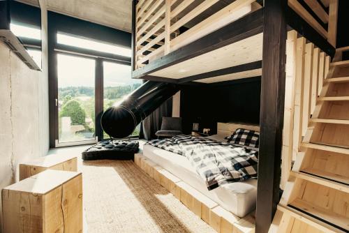 a bedroom with a bunk bed and a large window at Bretterhotel in Brienz