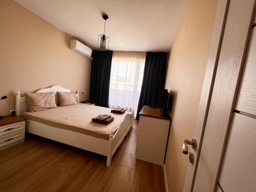 a small bedroom with a bed and a window at EMERALD SUITE with private parking in Varna City