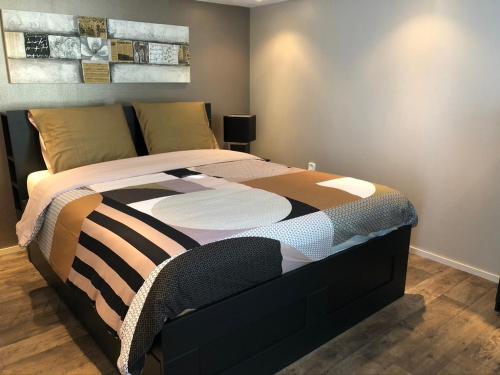 een slaapkamer met een bed met een zwart en bruin dekbed bij Vakantiehuis “Het Zeepaard” in Voorthuizen