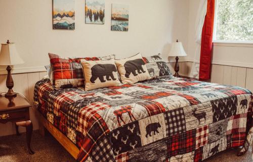 a bedroom with a bed with a plaid blanket at Pioneer Inn Downtown in Homer