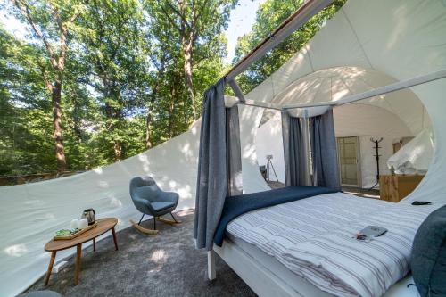 een slaapkamer in een tent met een bed en een bureau bij Nomád Glamping in Noszvaj