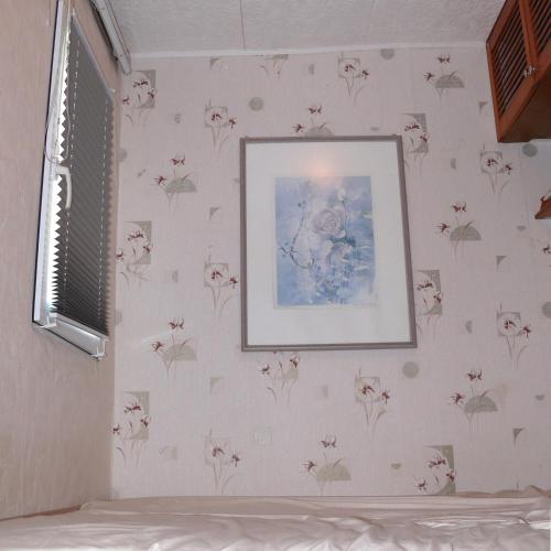 una camera da letto con carta da parati floreale e una foto sul muro di Bungalow im Märchengarten a Krauschwitz