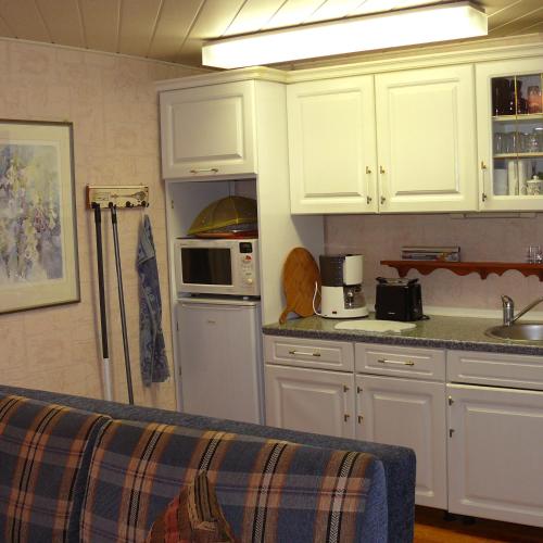 a kitchen with white cabinets and a counter top at Bungalow im Märchengarten in Krauschwitz