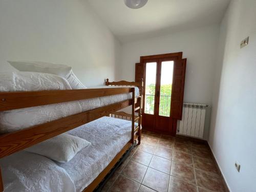 two bunk beds in a room with a window at Casa Rural - Vivienda Yunque in Puerto del Pino