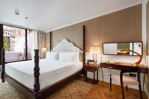 a hotel room with a bed and a desk and a window at BLESS Hotel Madrid - The Leading Hotels of the World in Madrid