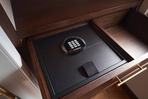 a remote control in a wooden box in a drawer at BLESS Hotel Madrid - The Leading Hotels of the World in Madrid