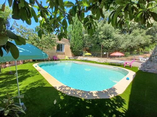 une piscine dans une cour avec un parasol dans l'établissement Bastide Saint Romain, à Salernes