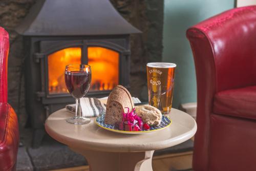 een tafel met een bord brood en een glas wijn bij The Exmoor Forest Inn in Simonsbath