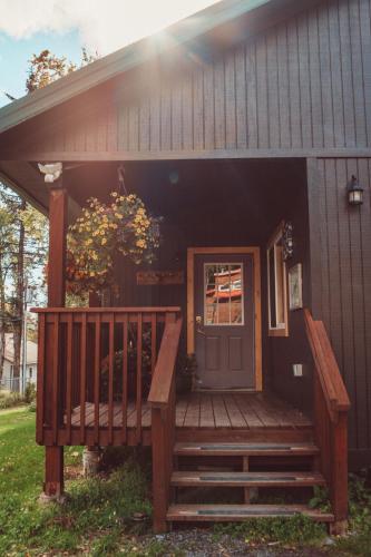 a house with a wooden porch with a door at Pioneer Inn Downtown in Homer