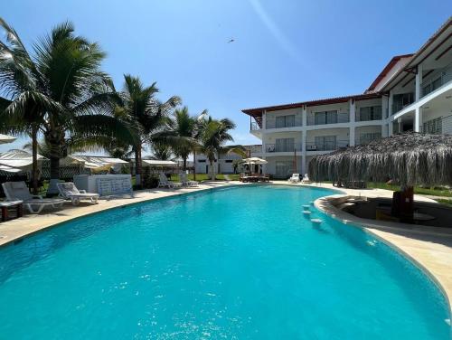 a swimming pool in front of a hotel at Hotel Hacienda Guamito in Puerto Pizarro