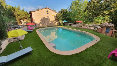 - une piscine avec un parasol dans la cour dans l'établissement Bastide Saint Romain, à Salernes