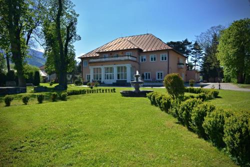 una casa grande con césped delante en Svatojansky Kastiel en Liptovský Ján