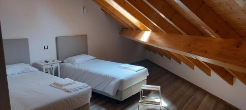 - une chambre avec deux lits et un plafond en bois dans l'établissement Alojamento Local - Covas, à Santiago do Cacém