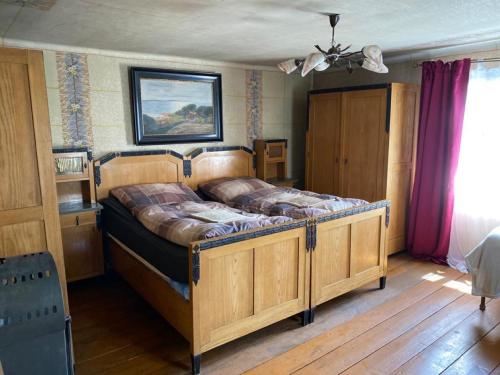 a bedroom with a large wooden bed in a room at Old Summer House with renovated bathroom in Prague
