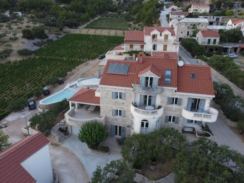 eine Luftansicht eines großen Herrenhauses mit rotem Dach in der Unterkunft Villa Franka with swimming pool in Bol