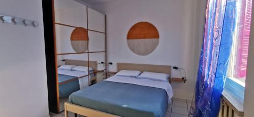 1 dormitorio con 2 camas y espejo en NUMANA, Bilocale con ampio balcone, en Numana