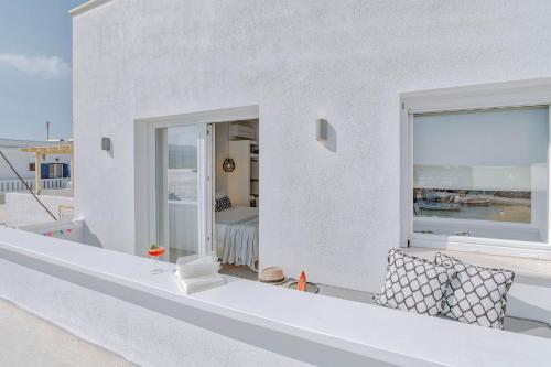 a white house with a balcony with a window at Nautica Suites-Superior Seaview suite with jacuzzi in Antiparos Town