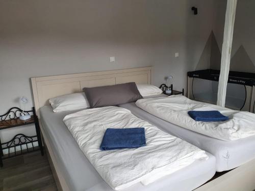 a white bed with two blue towels on it at Ferienhaus "Zum Blauen Hause" in Wernigerode