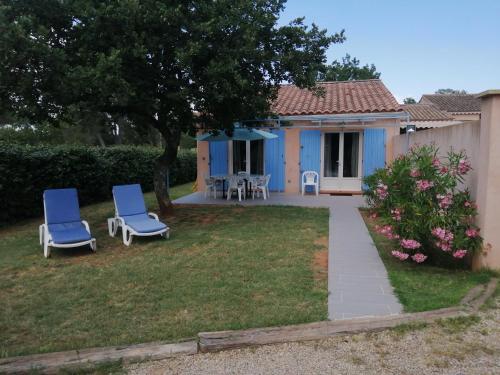 a house with two blue chairs in the yard at maison jumelée in Le Cannet-des-Maures