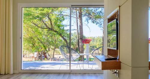a room with a sliding glass door with a table and chairs at Hotel Campo do Rosmaninho in Castelo Branco