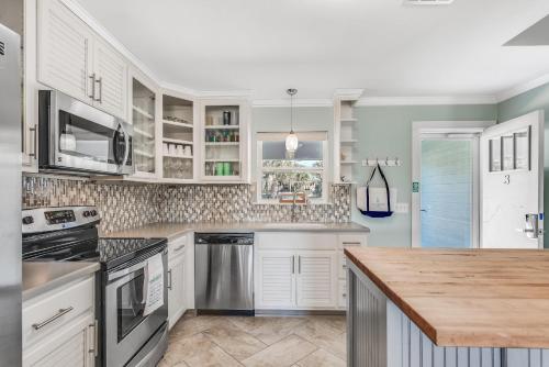 a kitchen with white cabinets and a wooden counter top at Sunnyside on the Gulf #3 in Sunnyside