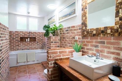 a bathroom with a brick wall and a sink at 10 Bedroom 5 Star Luxury Villa & Heated Pool for 5 to 28 Guests near Alicante in Mutxamel