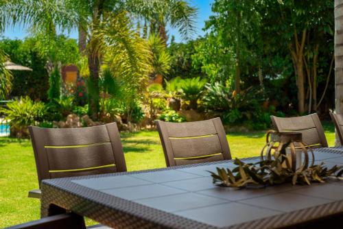a table with three chairs and a table and a table and chairs at 10 Bedroom 5 Star Luxury Villa & Heated Pool for 5 to 28 Guests near Alicante in Mutxamel