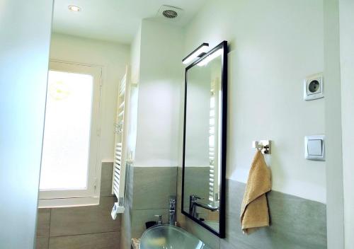 a bathroom with a sink and a mirror at Loueurdappart - Studio Cosy, Très jolie Vue Mer, Tout à pied à la Baule in La Baule