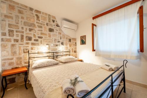 a bedroom with a bed and a stone wall at Seafront Villa Endless View in Blato