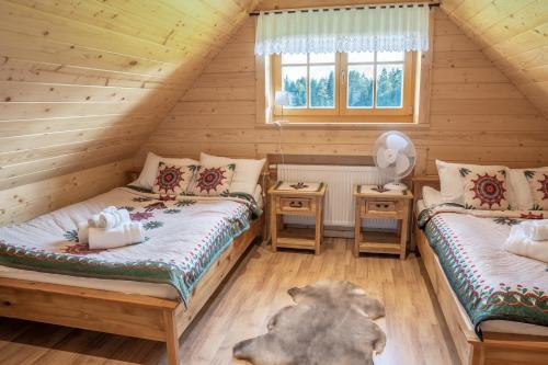 1 Schlafzimmer mit 2 Betten in einem Blockhaus in der Unterkunft Agroturystyka "Na Zogrodzie" Alicja Kowalczyk in Harklowa