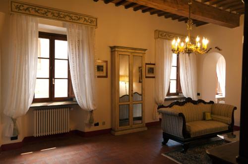 a living room with a chair and windows at Palazzo Benucci in San Gimignano