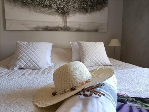 a straw hat is sitting on a bed at La Ferme Les Eybrachas in Réauville