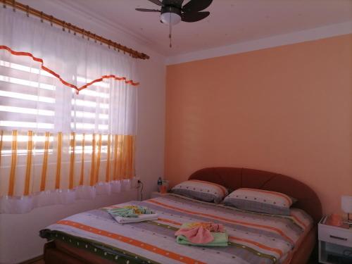 a bedroom with a bed and a window with curtains at Prenoćište " Ruža" in Višegrad